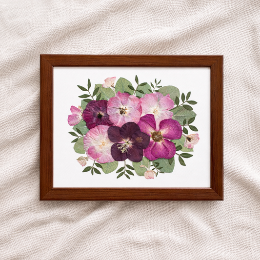 Kisebb méretű préselt csokor falra akasztható kivitelben. Rózsaszín virágokkal és zöld levelekkel.