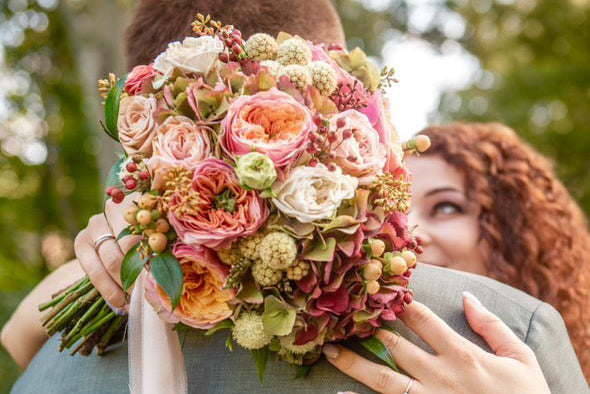 színes őszi menyasszonyi csokor egy menyasszony kezében 