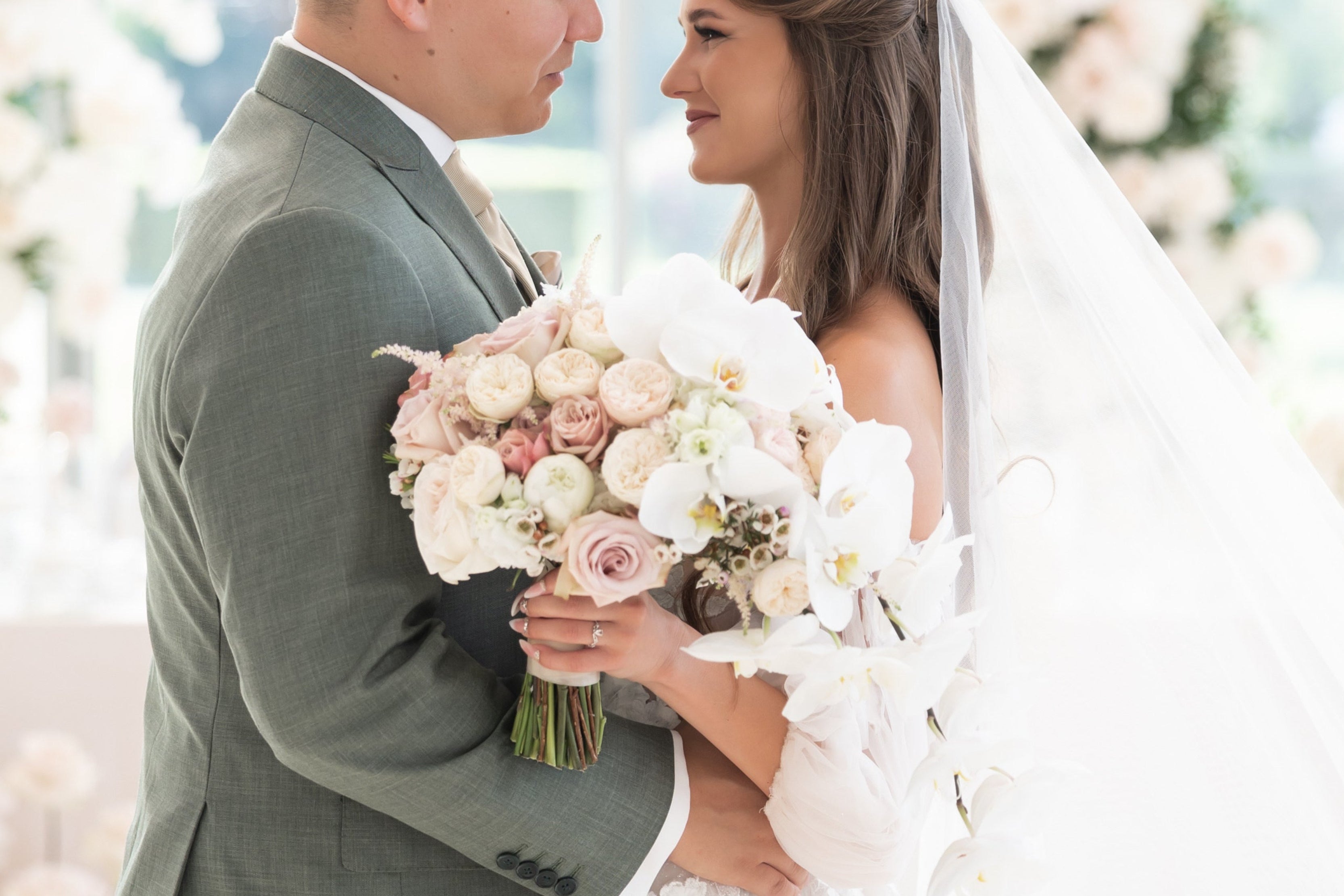 menyasszony fogja csokrát, ami fehér és rózsaszín virágokat tartalmaz 